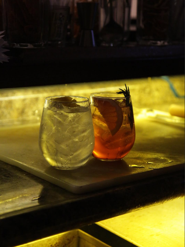 Dos cócteles en la barra iluminada